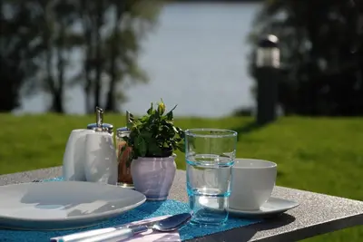 a table with plates and cups and a glass of water at Šiker B&B Hotel in Pernica