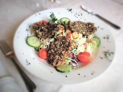 a plate of food with a salad on a table at Šiker B&B Hotel in Pernica