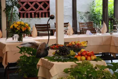 a bird sitting on a table with fruits and vegetables at Šiker B&B Hotel in Pernica
