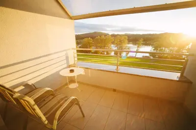 a balcony with a chair and a table and a window at Šiker B&B Hotel in Pernica