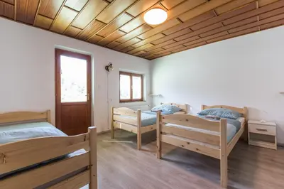 two beds in a room with wooden ceilings at Dolar Rooms in Bled