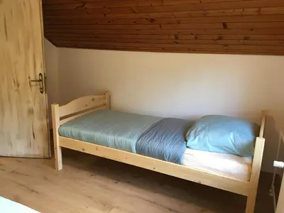 a bed in a room with a wooden frame at Dolar Rooms in Bled