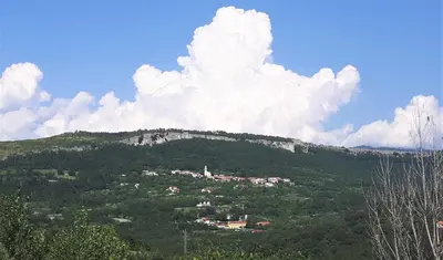 a mountain with a town on top of it at Relax in Črni Kal in Črni Kal