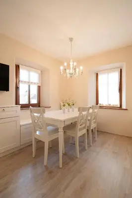 a white dining room with a white table and chairs at Pr`Mružo apartmaji in Bohinj