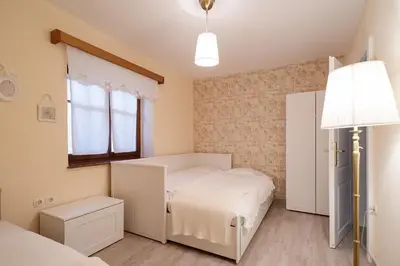 a small bedroom with a bed and a lamp at Pr`Mružo apartmaji in Bohinj