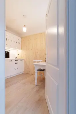 a kitchen with a table and a white refrigerator at Pr`Mružo apartmaji in Bohinj