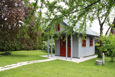 a small house with red doors in a yard at Apartments Poldi in Bled