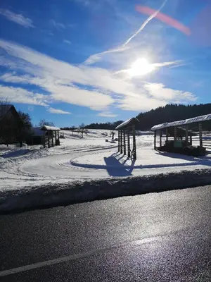a road with snow on the ground next to a building at Apartmaji Volf in Zgornje Gorje