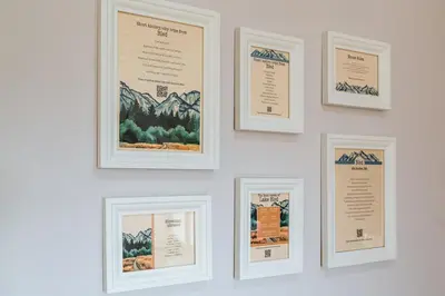 a wall with four framed pictures on a wall at Apartma Lilly in Bled