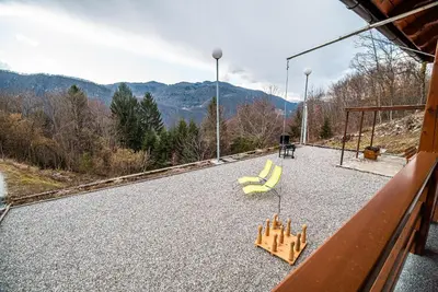 a balcony with two yellow chairs and mountains in the background at Valley View Holiday Home with Sauna Mrak in Slappe dʼIdria
