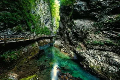 a river in a canyon with a bridge over it at Hostel Bled Paradise Slovenia in Bled-Rečica