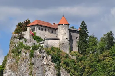 a castle on the side of a mountain at Hostel Bled Paradise Slovenia in Bled-Rečica