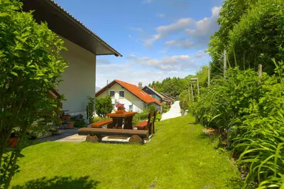a garden with a table and a bench in a yard at Apartments Rikli Rodine near Bled in Rodine