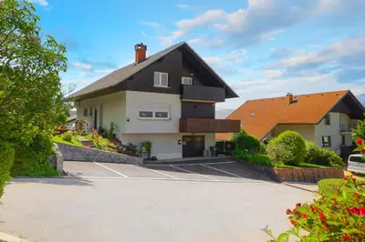 a building with a parking lot in front of it at Apartments Rikli Rodine near Bled in Rodine