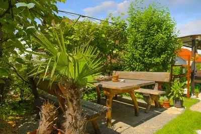 a wooden picnic table and bench in a garden at Apartments Rikli Rodine near Bled in Rodine