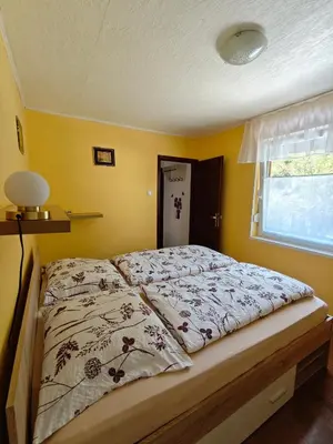 a bed in a bedroom with a yellow wall at Apartma Evi in Žaga