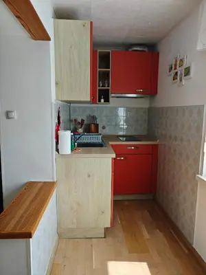 a small kitchen with red cabinets and red counters at Apartma Evi in Žaga