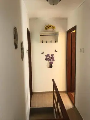 a hallway with a staircase with a vase of flowers on the wall at Apartma Evi in Žaga