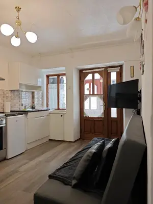 a living room with a couch and a kitchen at Apartma Evi in Žaga