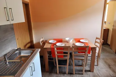 a kitchen with a table with chairs around it at Apartma Marjetica II. in Blejska Dobrava