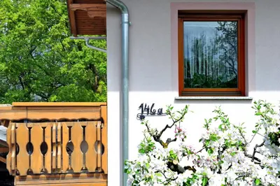 a house with a window and a flowering tree at Apartma Marjetica II. in Blejska Dobrava