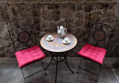 a table with pink chairs and a vase on it at Apartma Marjetica II. in Blejska Dobrava