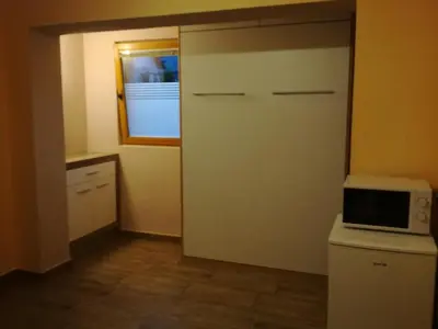 a small kitchen with a refrigerator and a microwave at Apartma Marjetica II. in Blejska Dobrava