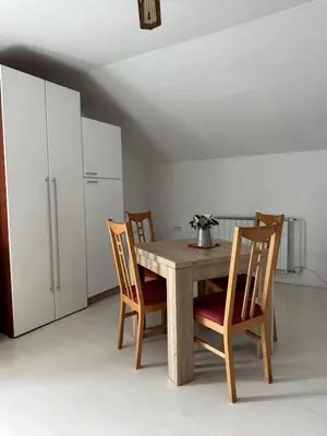 a kitchen with a wooden table and chairs at Apartments and Wellness Ščavničar in Ljutomer