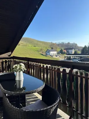a table with a vase sitting on a balcony at Apartments and Wellness Ščavničar in Ljutomer