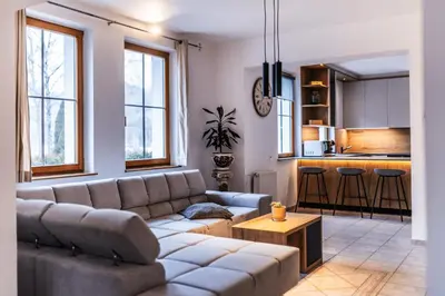 a living room with a couch and a kitchen at Vila Grad Bled - Sauna & Hot tub in Bled