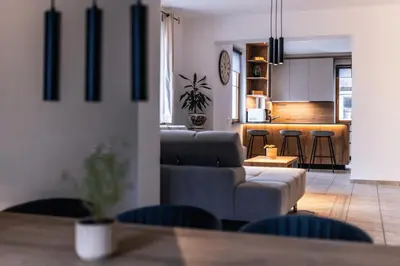 a living room with a couch and a kitchen at Vila Grad Bled - Sauna & Hot tub in Bled