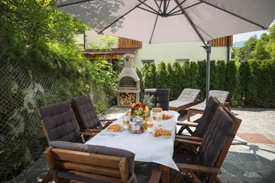 a table with food and an umbrella on a patio at Vila Grad Bled - Sauna & Hot tub in Bled