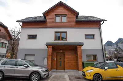 a house with two cars parked in front of it at Luxury apartment with a nice view in Kranjska Gora in Kranjska Gora
