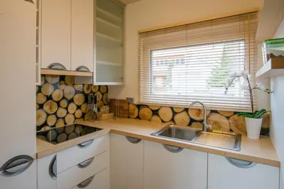 a kitchen with white cabinets and a sink and a window at Luxury apartment with a nice view in Kranjska Gora in Kranjska Gora