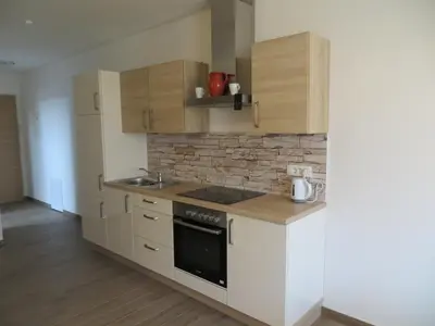 a kitchen with white cabinets and a stove top oven at Apartments and Wellness Jelovca in Radovljica