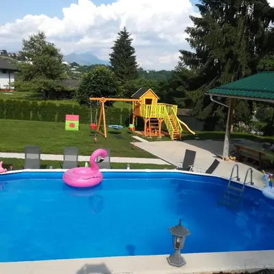 a swimming pool with a pink swan in a playground at Apartments and Wellness Jelovca in Radovljica