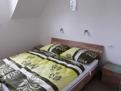 a bed with black and yellow blankets and pillows at Apartments and Wellness Jelovca in Radovljica