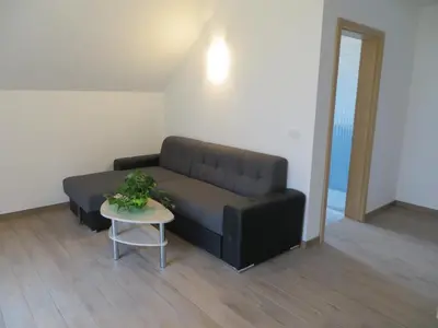 a black couch in a living room with a table at Apartments and Wellness Jelovca in Radovljica