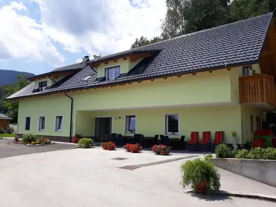 a building with red chairs and a patio at Apartments and Wellness Jelovca in Radovljica