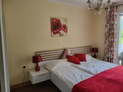 a bedroom with a bed with red pillows on it at Soča House in Kobarid