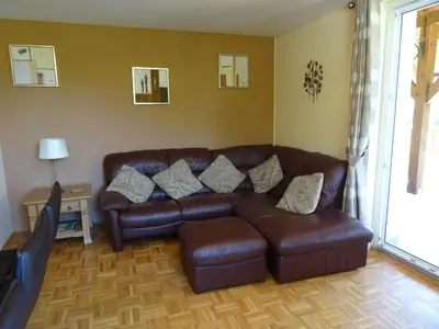 a brown leather couch in a living room with a television at Soča House in Kobarid