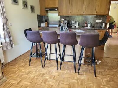 a kitchen with four bar stools in front of a counter at Soča House in Kobarid