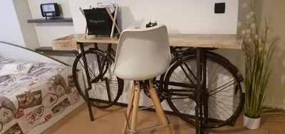 a bike parked next to a table with a white chair at Apartment Central Station between Dragon and Triple Bridges in Ljubljana