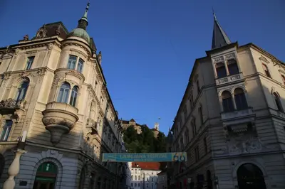 a street sign in front of two buildings at Apartment Central Station between Dragon and Triple Bridges in Ljubljana