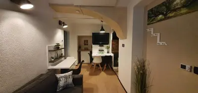 a living room with a table and a desk in a apartment at Apartment Central Station between Dragon and Triple Bridges in Ljubljana