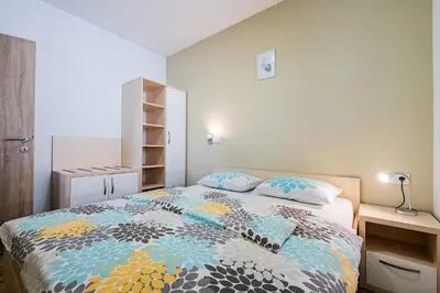 a bedroom with a bed with a colorful comforter at Apartmaji BANONIA 