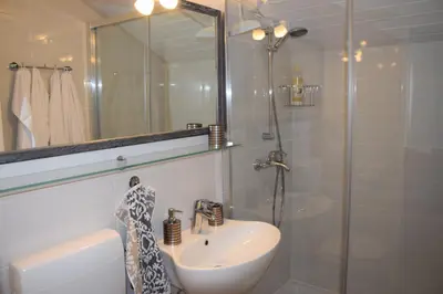 a white bathroom with a sink and a shower at Studio Tara with balcony in Bled