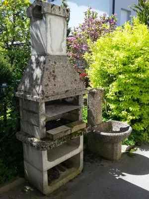 a stone oven in a garden with a bird bath at Vila Bbq in Ljubljana