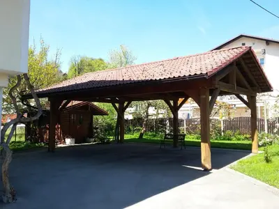a wooden pavilion with a roof on a sidewalk at Vila Bbq in Ljubljana