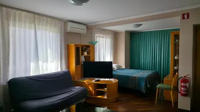 a bedroom with a bed and a chair and a table at Vila Bbq in Ljubljana